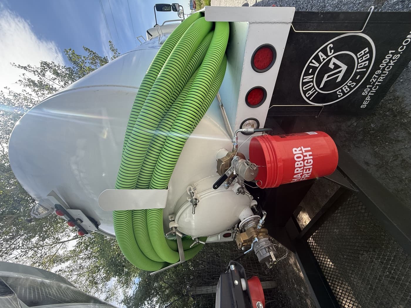 Green septic hose and pump fittings on the back of the Open Range truck.