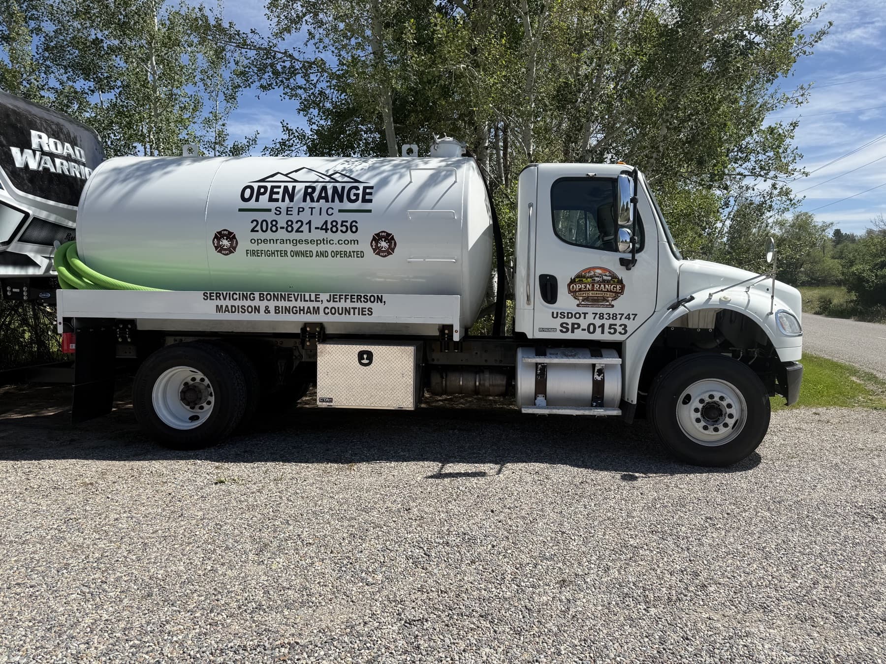 Full Open Range Septic pump truck parked on gravel with the service branding visible on the tank.